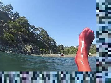 Red stocking in the sea on a public beach