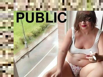 Chubby girlfriend sitting on the window in public, writes on her saggy tits that she is a SLUT.