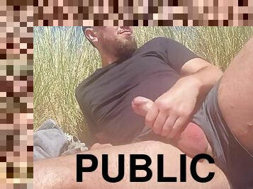 Bearded guy cums on a public beach