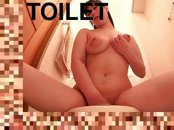 Kinky brunette babe fingers wet pussy in the toilet