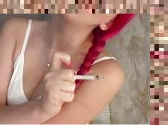 Girl with a tattoo smokes a cigarette